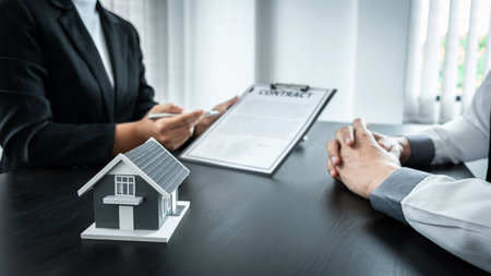 Estate agent broker presentating to client decision signing agreement contract real estate with approved mortgage application, buying mortgage loan offer for and house insurance.の写真素材