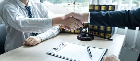 Handshake after consultation between a male lawyer and client, giving advice and prosecutions about the regarding estate.の写真素材