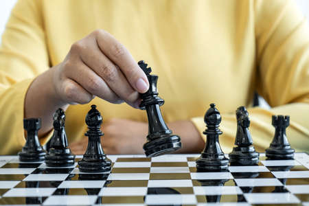 Woman playing chess and thinking strategy plan about crash overthrow the opposite team and development analyze for successful.の写真素材
