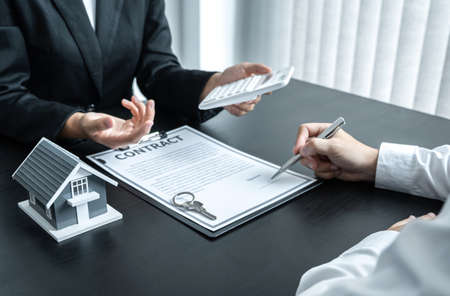 Estate agent broker presentating to client decision signing agreement contract real estate with approved mortgage application, buying mortgage loan offer for and house insurance.の写真素材