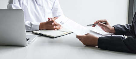 Employer or committee holding reading a resume with talking during about his profile of candidate, employer in suit is conducting a job interview, manager resource employment and recruitment concept.の写真素材