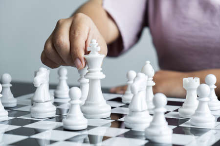 Woman playing chess and thinking strategy plan about crash overthrow the opposite team and development analyze for successful.の写真素材