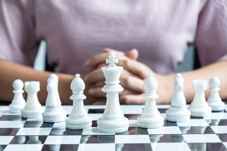 Woman playing chess and thinking strategy plan about crash overthrow the opposite team and development analyze for successful.の写真素材