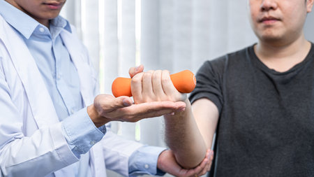 Young asian physiotherapist gives advice on how to properly lifting dumbbells during physical therapy sessions in the clinicの写真素材