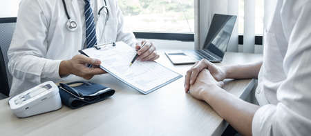 Doctor consulting with the patient and checking sickness condition while presenting results diagnosis symptom examining about the problem of illness and recommend treatment method.の写真素材