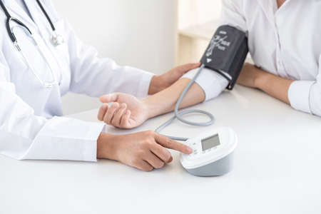Doctor using a measuring blood pressure checking patient with examining, presenting results symptom and recommend treatment method, Healthcare and medical concept.の写真素材