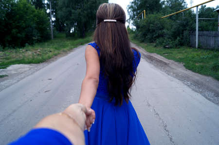 The girl leads her friend along the road with herの写真素材