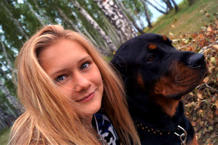 The girl in the woods with her pet Rottweilerの写真素材