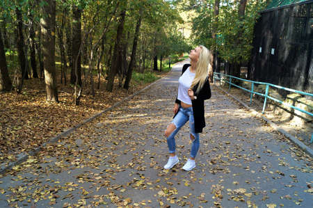 The girl in the Park among the green trees and yellow leavesの写真素材