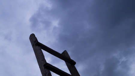 Wooden staircase leading to the blue sky with fluffy cloudsの写真素材