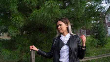 Beautiful young girl on a background of green Siberian cedar in the springの写真素材