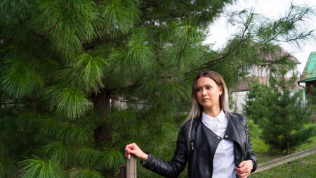 Beautiful young girl on a background of green Siberian cedar in the springの写真素材