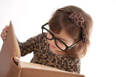 Child reading a book wearing large glassesの写真素材