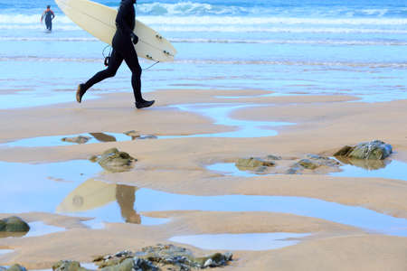 Surfer running on the beachの写真素材