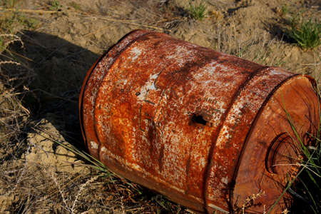 Old barrel in weeds with bullet hole.の写真素材