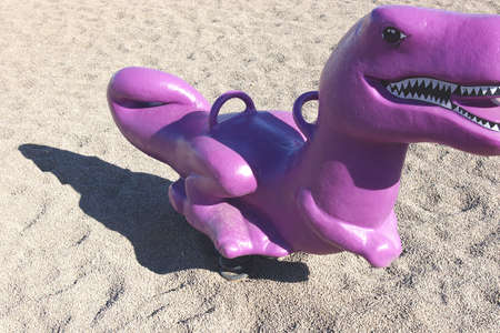 Purple toy dinosaur at children's playground.の写真素材