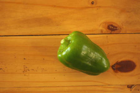 Fresh picked green bell pepper on pine table.の写真素材