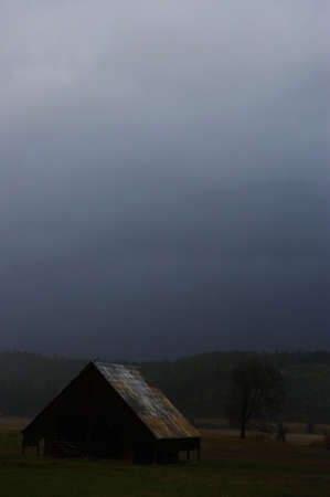 Old, dark barn in a rain storm.の写真素材