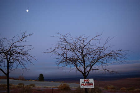 Sign on a tree by a golf course restricting parking for boats, buses, and RVs.
