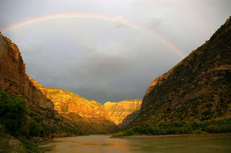 A rainbow spanning a river canyon after a thunderstorm.の写真素材