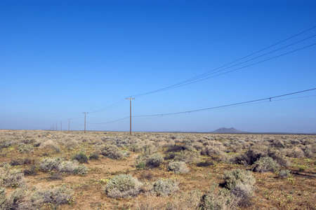 Remote powerline in an empty desert landscape.の写真素材