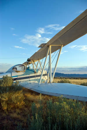 An old crop-dusting bi-plane abandoned in an overgrown field.の写真素材