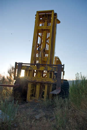 An old forklift abandoned in a field at sunrise.の写真素材