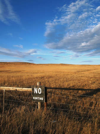 A painted sign warns against hunting the open prairie.の写真素材