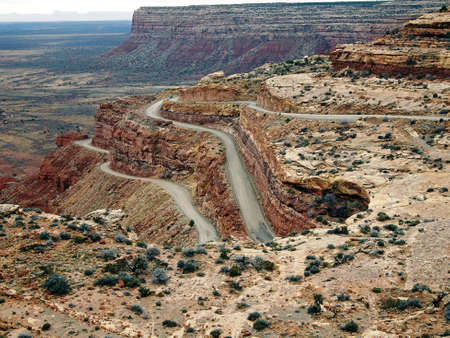 A rural road winds steeply down the face of a cliff.の写真素材