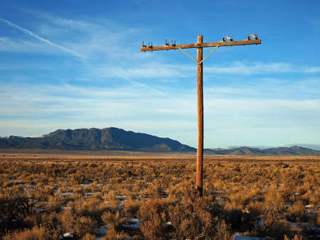 An abandoned power pole in an empty, high desert landscape.の写真素材