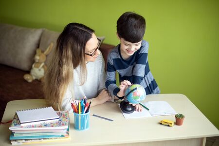 Boy with mother doing homework during the quarantine. Social distance, self-isolation, homeschooling concept.の写真素材