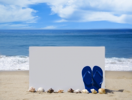White board with flip-flops and seashells on sandy beach の写真素材