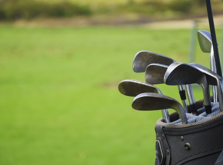Golf bag with clubs after play on green grass backgroundの写真素材