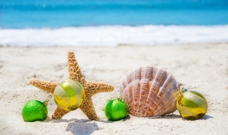 Starfish and seashell with Christmas balls on sandy beach in sunny day- holiday conceptの写真素材