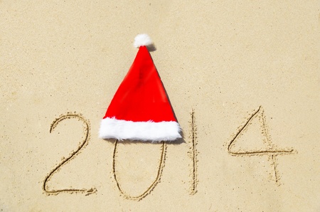 Number 2014 with christmas hat on the sandy beach - holiday conceptの写真素材