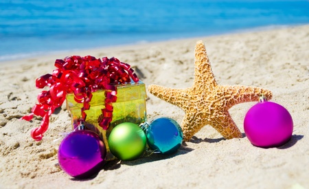 Starfish with gift box and christmas balls on the beach by the ocean - holiday conceptの写真素材