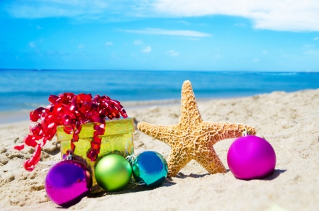 Starfish with gift box and christmas balls on the beach by the ocean - holiday conceptの写真素材