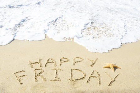 Sign "Happy Friday" on the sandy beach by the oceanの写真素材