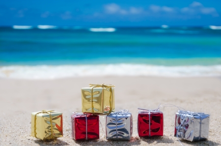 Few Christmas gift box on the sandy beach by the oceanの写真素材