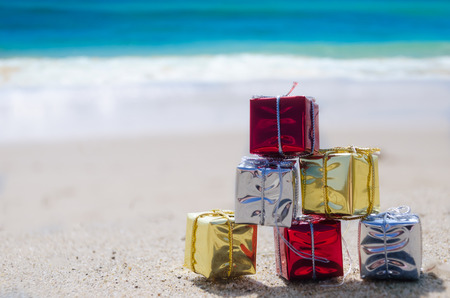 Few Christmas gift box on the sandy beach by the oceanの写真素材
