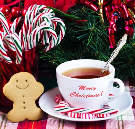 Tea with Christmas candy and gingerbread man on holiday's 