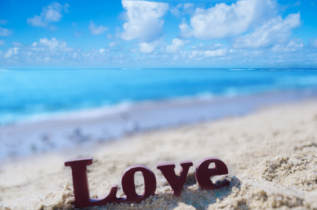 Sign "LOVE" on the sandy beach by the oceanの写真素材
