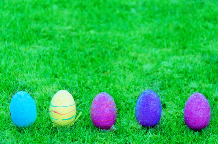 five color easter eggs on the grass