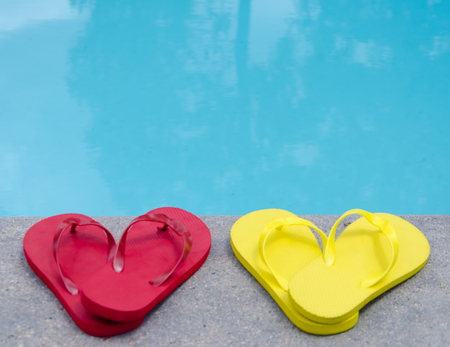 Color flip flops by the swimming pool in sunny dayの写真素材