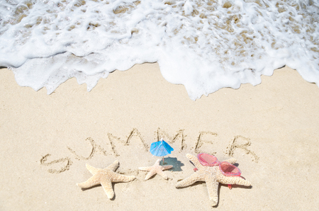 Sign "Summer" and starfishes family on the sandy beachの写真素材