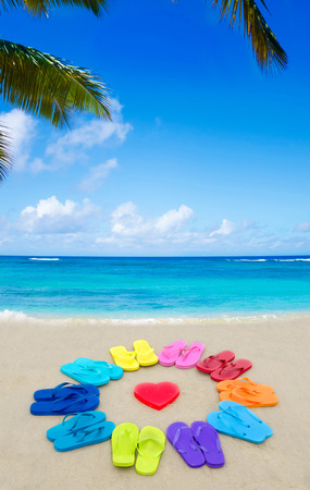 Color Flip flops and heart on the sandy beach by oceanの写真素材