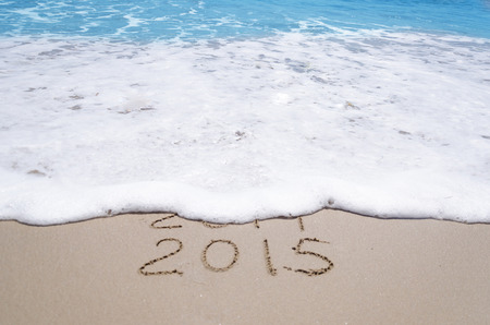 Sign 2014 and 2015 on the sandy beach by ocean