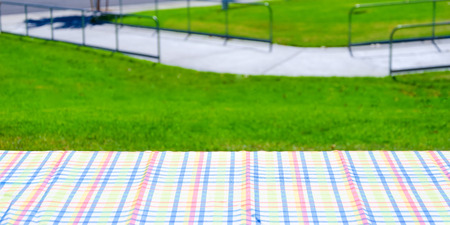 Picnic colorful tablecloth textile on the table with grass background