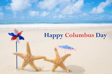 Columbus Day background with starfishes and decorations on the sandy beachの写真素材