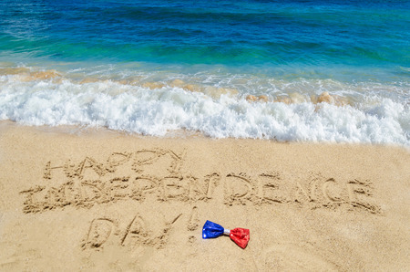 Happy Independence Day USA background with holidays bow on the sandy beach (4th of july holiday concept)の写真素材